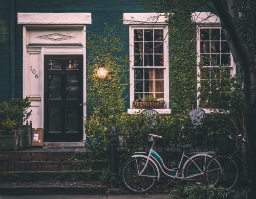 house covered in ivy with bicycle out front